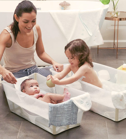 Madre ba&ntilde;ando a sus hijas en ba&ntilde;era Plagable Flex Bath